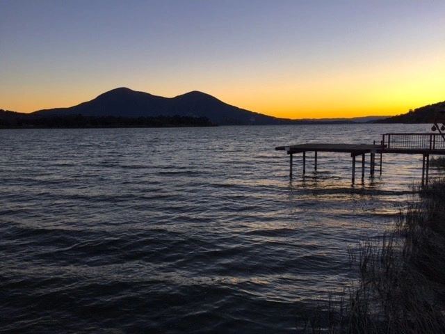 Mountain silhouette across lake at dusk
